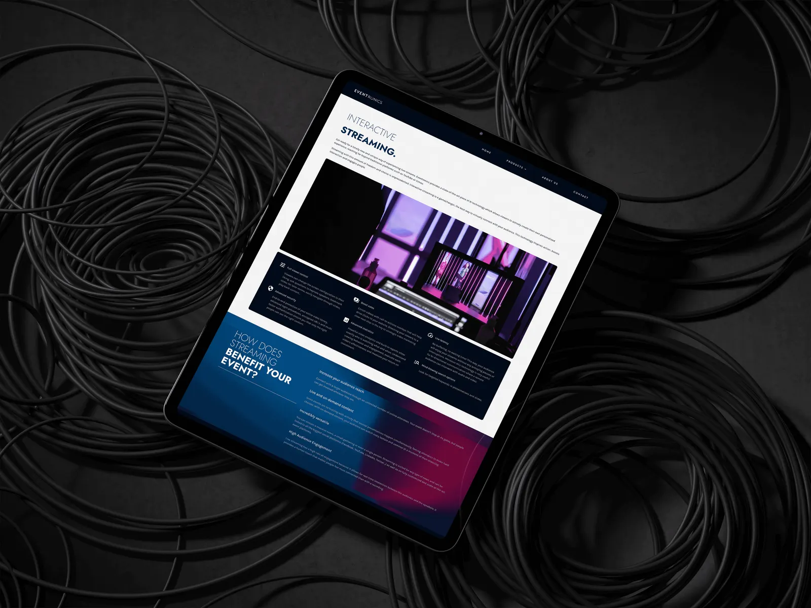 The Eventronics site open on a tablet, lying on a bed of coiled black cable
